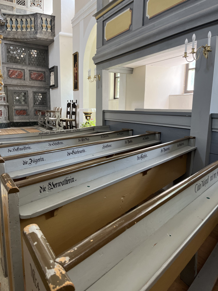 Kirchenbänke mit den jeweiligen Berufsständen zugewiesenen Plätzen