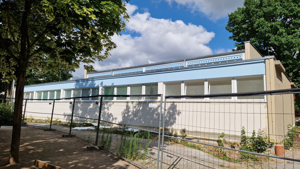 Die nebenan bestehende Turnhalle wurde nachträglich denkmalgerecht saniert und wird voraussichtlich im Herbst 2026 eingeweiht; Stand 2026