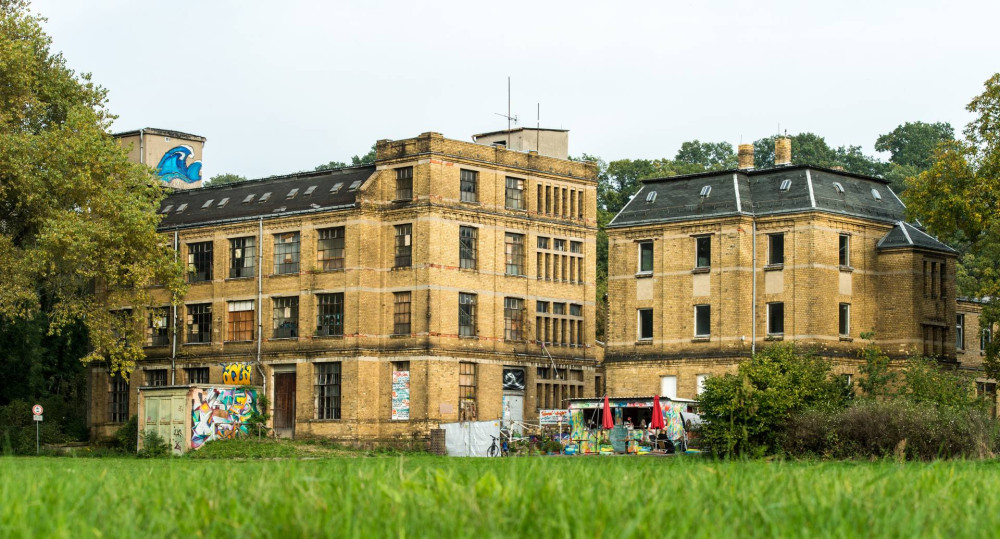 Ansicht der Spitzenfabrik mit dem davor liegenden Container-Café