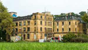 Ansicht der Spitzenfabrik mit dem davor liegenden Container-Café