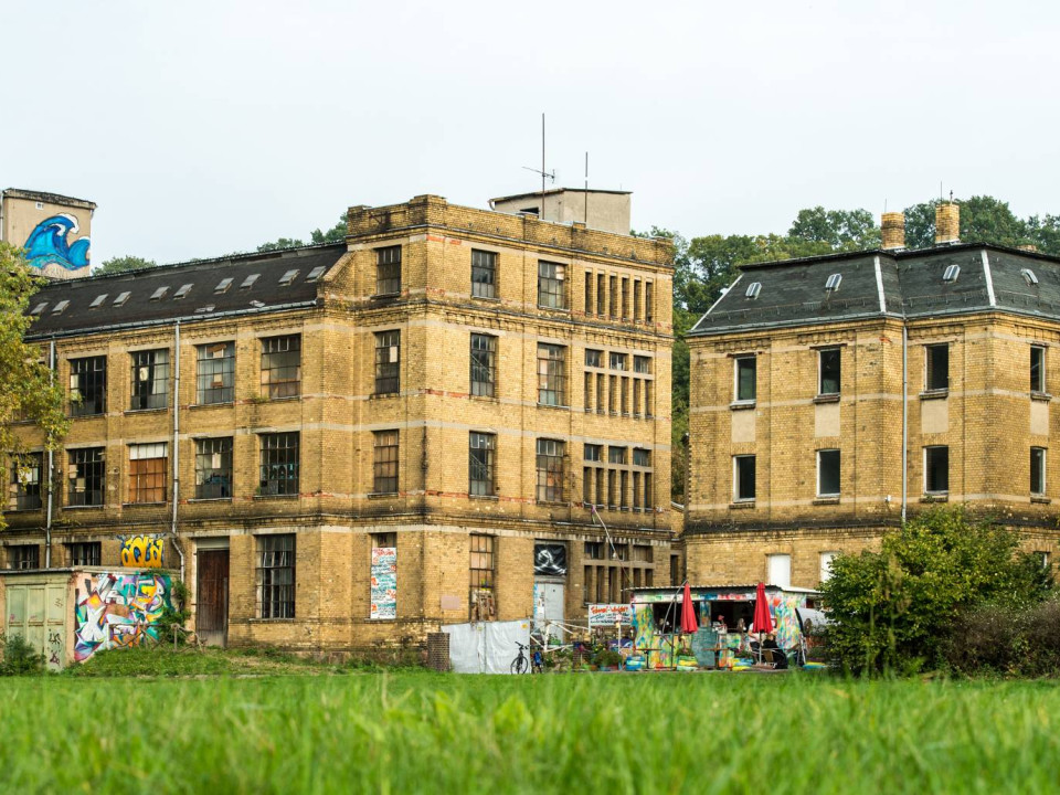 Ansicht der Spitzenfabrik mit dem davor liegenden Container-Café